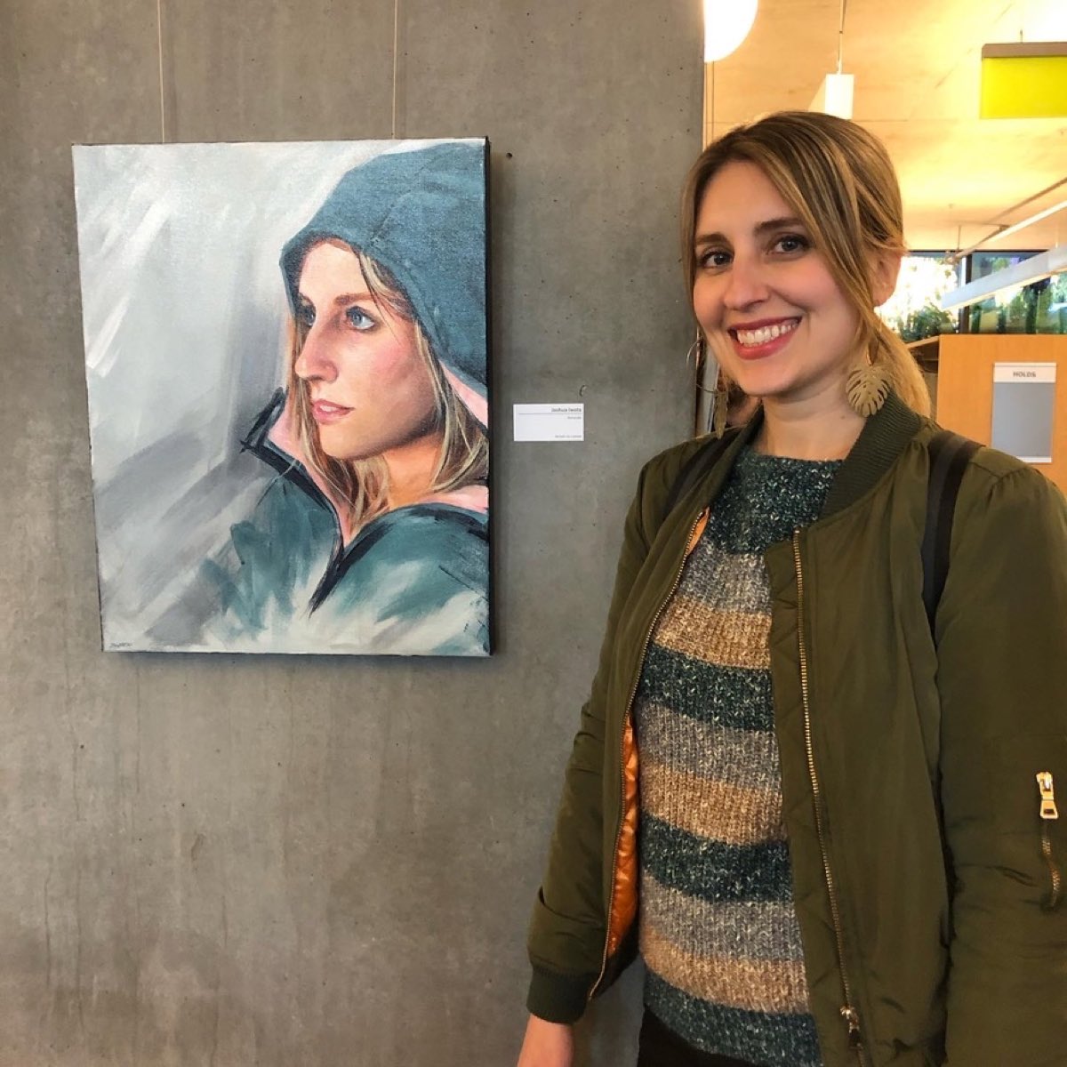 A visitor viewing a hooded-figure portrait